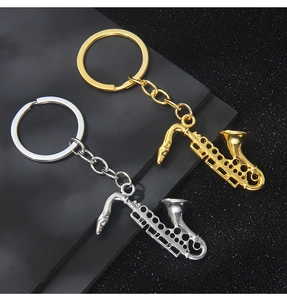 Macro shot of gold and silver saxophone musical instrument keychains with polished finish