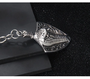 Macro detail of antique silver shield pendant with embossed portrait and metal chain link