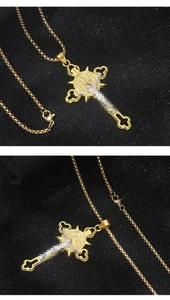 Primo piano di una collana vintage con croce in acciaio inossidabile dorato su nero