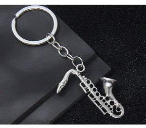 Macro detail of a silver saxophone keychain with realistic instrument key carvings