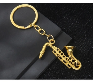 Detailed close-up of a golden saxophone keychain with realistic instrument textures