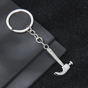 Porte-clés marteau miniature en métal argenté avec poignée texturée et finition polie