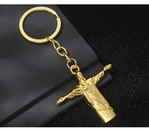 Detail of golden Rio Christ the Redeemer keychain with polished metal finish on dark background