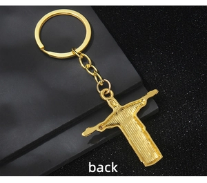 Detailed back view of golden metal cross keychain with brushed texture finish