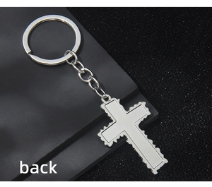 Silver alloy cross keychain with jagged edges and back view on black base