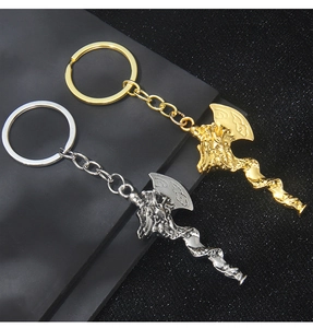 Detail of dragon-embossed Viking battle axe keychains in gold and silver metal finishes