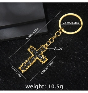 Detailed view of golden alloy cross keychain with black enamel inlay and circular ring