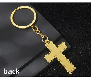 Flat back view of gold cross keychain with serrated edges and polished metal finish