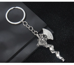 Macro shot of silver Viking battle axe keychain with intricate cloud engraving details