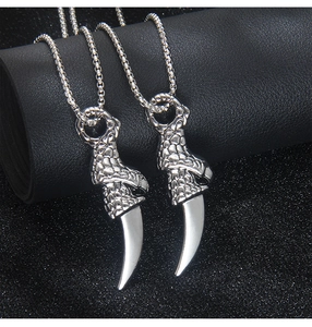 Macro detail of gothic dragon claw pendant necklaces with silver box chain style