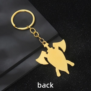 Porte-clés double hache viking dorée avec symboles runiques sur fond noir texturé