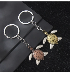 Dettaglio ravvicinato di portachiavi tartaruga vintage con texture in bronzo e argento