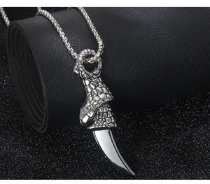 Macro detail of gothic dragon claw pendant with silver bone tooth and steel box chain
