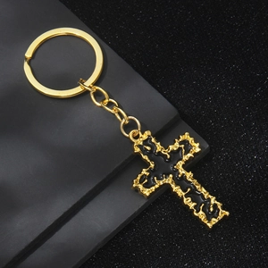 Minimalist gold cross keychain with black enamel inlay and textured wavy golden edges
