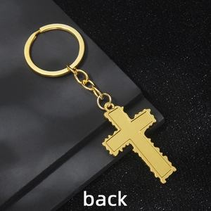 Minimalist gold cross keychain with decorative edges and polished finish on dark background