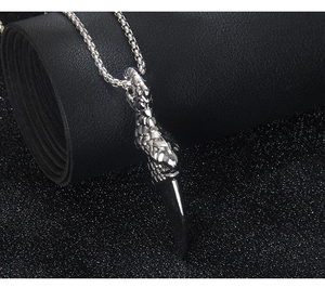 Macro detail of polished stainless steel dragon claw pendant on a long bead chain