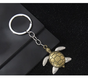 Dettaglio macro del portachiavi tartaruga vintage con guscio bronzo e arti argento