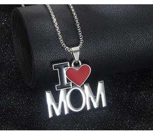 Vue macro du pendentif MOM en acier inoxydable avec cœur en émail rouge sur chaîne