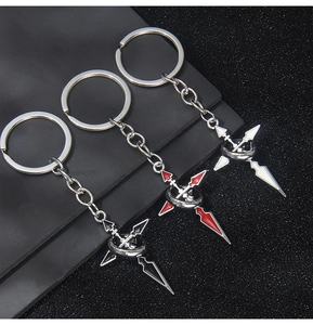 Détail de porte-clés croix en émail noir, rouge et blanc avec anneau métallique