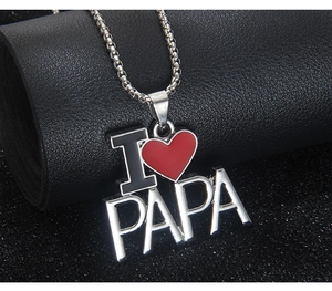 Vue macro détaillée du collier I Love PAPA en acier argenté avec pendentif cœur rouge