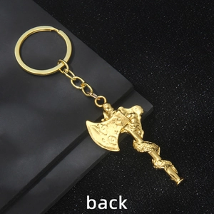 Golden dragon-wrapped Viking axe metal keychain, detailed back view on matte surface