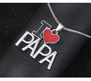 Détail macro du collier I Love PAPA en acier inoxydable avec pendentif cœur rouge