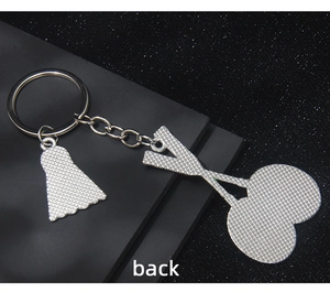 Detailed back view of silver badminton racket and shuttlecock keychain with mesh texture