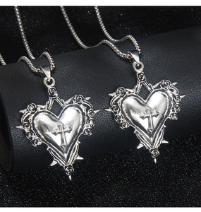 Vue détaillée du pendentif croix coeur gothique avec épines argentées et relief rose
