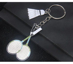 Detail of silver badminton racket and shuttlecock keychain charms with enamel accents
