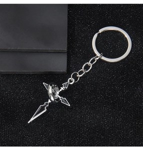 Détail du porte-clés pendentif croix en métal avec émail noir sur fond sombre texturé