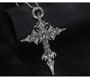 Vue détaillée du pendentif croix gothique argentée avec crâne et gravure 'DIE LAST'