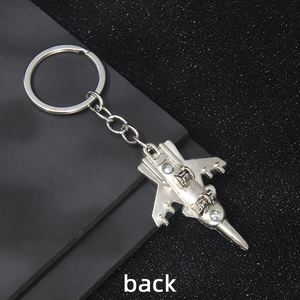 Vintage silver fighter jet keychain made of alloy metal, shown from back view perspective