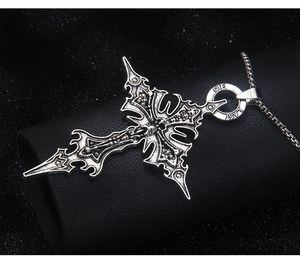 Gros plan du pendentif croix gothique avec motifs de crâne et texture argentée