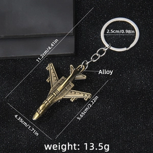 Vintage bronze fighter jet keychain in zinc alloy displayed on a textured black surface