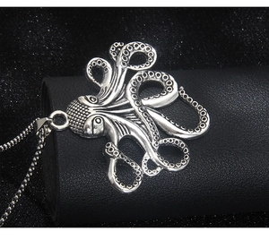 Gros plan du pendentif poulpe montrant la texture vintage et les détails des ventouses
