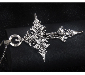 Vue macro du pendentif croix gothique à crânes avec gravure LAST OIE sur un coffret