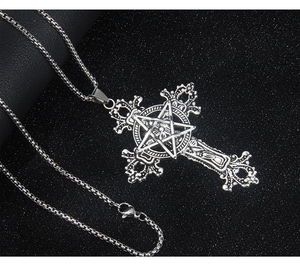 Close-up of vintage gothic stainless steel cross necklace with star detail on black velvet