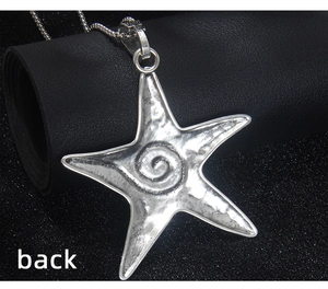 Détail macro de la face arrière d'un pendentif étoile de mer argenté avec texture martelée