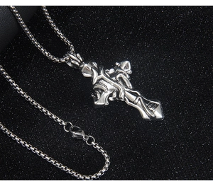 Gros plan sur pendentif croix gothique avec relief de vigne et fini argent antique