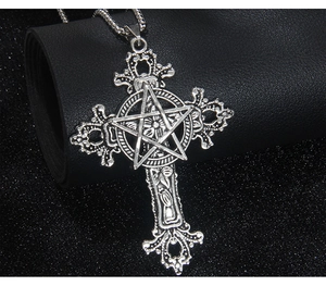 Macro view of vintage punk stainless steel necklace with cross and pentagram pendant