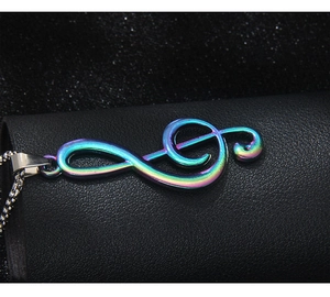 Vue macro du pendentif clé de sol arc-en-ciel sur une chaîne en acier inoxydable