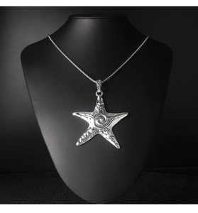 Détail d'un collier pendentif étoile de mer argentée avec texture martelée sur mannequin