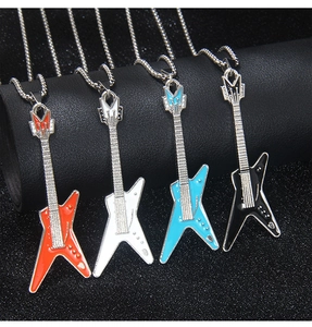 Détail de quatre pendentifs guitare électrique en rouge, blanc, bleu et noir avec strass
