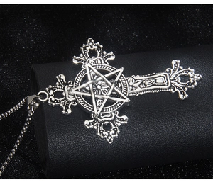 Macro shot of vintage silver cross pendant with pentagram and floral carvings