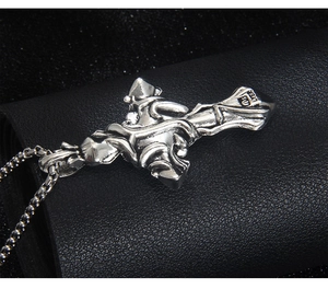Détail macro du pendentif croix gothique avec texture de vigne sur cuir noir