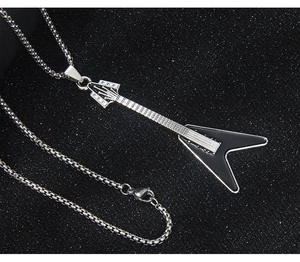 Detail shot of Flying V electric guitar pendant in silver finish with black enamel inlays
