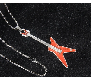 Vue macro du pendentif guitare avec émail orange et chaîne à billes en acier inoxydable