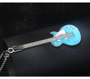 Vue macro d'un pendentif guitare électrique bleu ciel orné de cristaux brillants