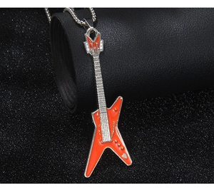 Vue macro détaillée d'un pendentif guitare électrique orange sur une chaîne en métal
