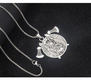 Macro detail of Viking warrior shield pendant with twin axes and silver metal texture